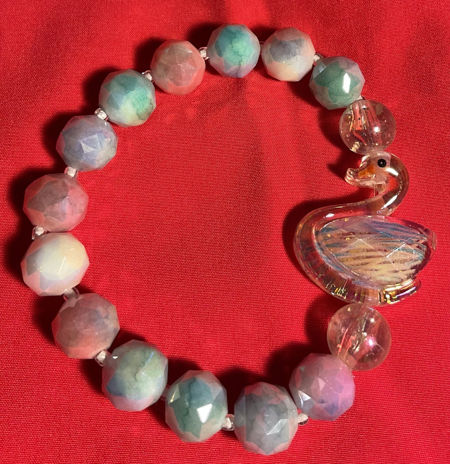 Iridescent swan with pearl rainbow accents bracelet on 7 inch elastic thread. Adjustable.