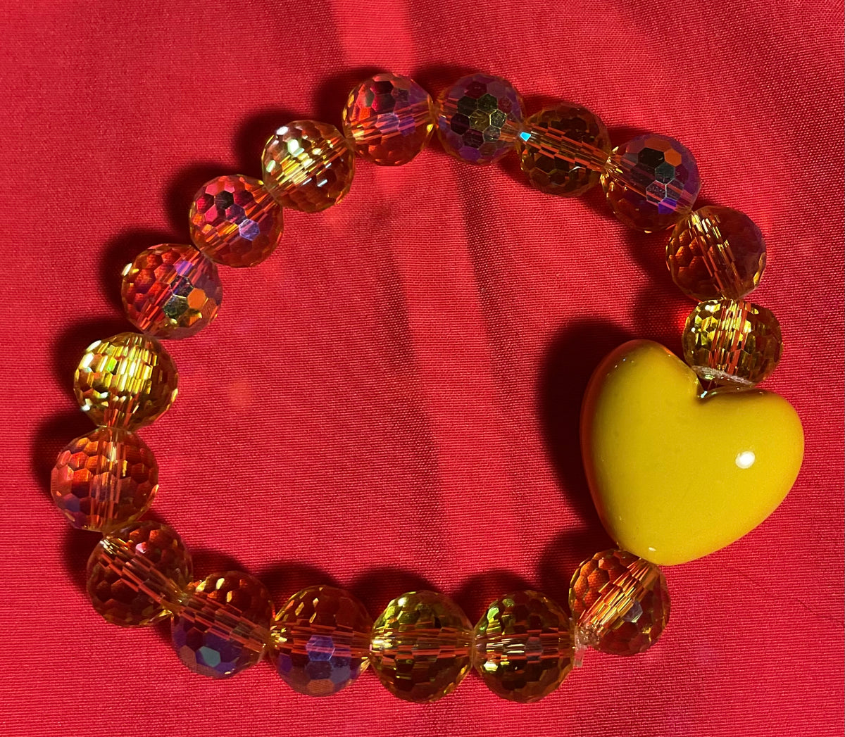 Yellow heart with clear gold accents bracelet on 7 inch elastic thread. Adjustable.